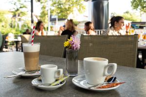 Kaffeespezialitäten mit Milchschaum serviert auf der sonnigen Terrasse