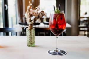 Fruchtiges Aperitif im Glas neben Blume